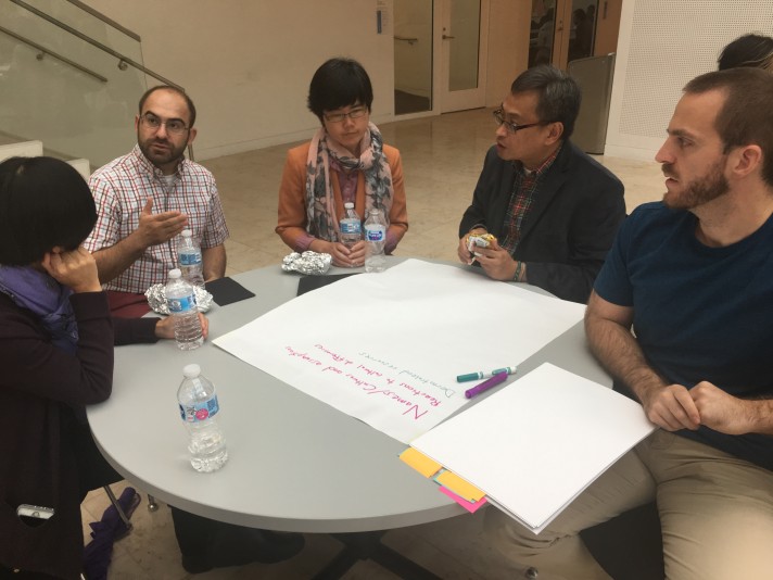 Group of 5 people discussing items to place on a poster